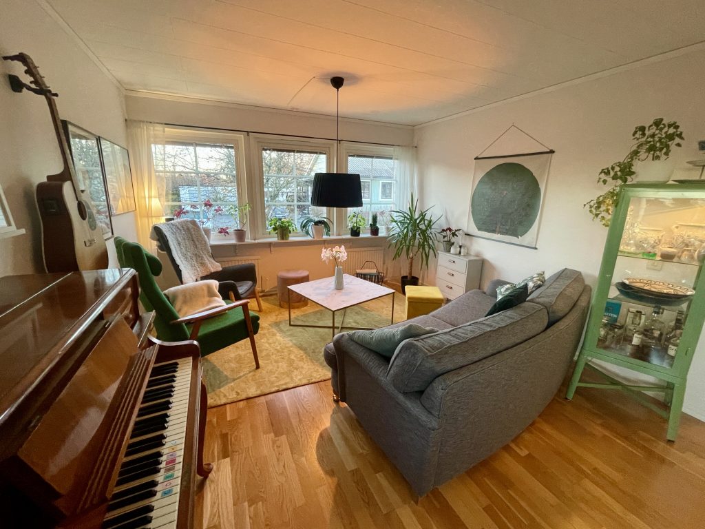 Vardagsrum med piano soffa obord och fotäljer